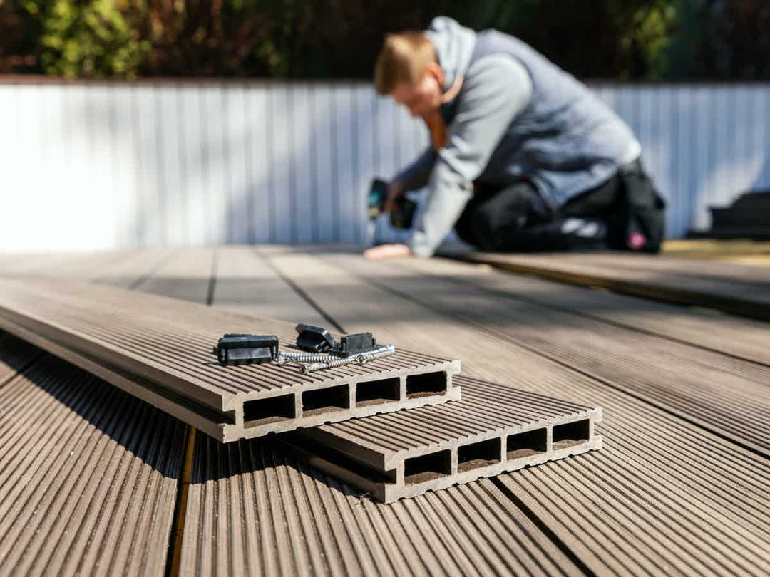 Workman laying composite wood decking